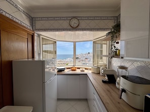 A kitchen with a view of the sea, a clock, and a modern design. - ALBUFEIRA AMAZING VIEW 2 WITH POOL by HOMING (Albufeira)