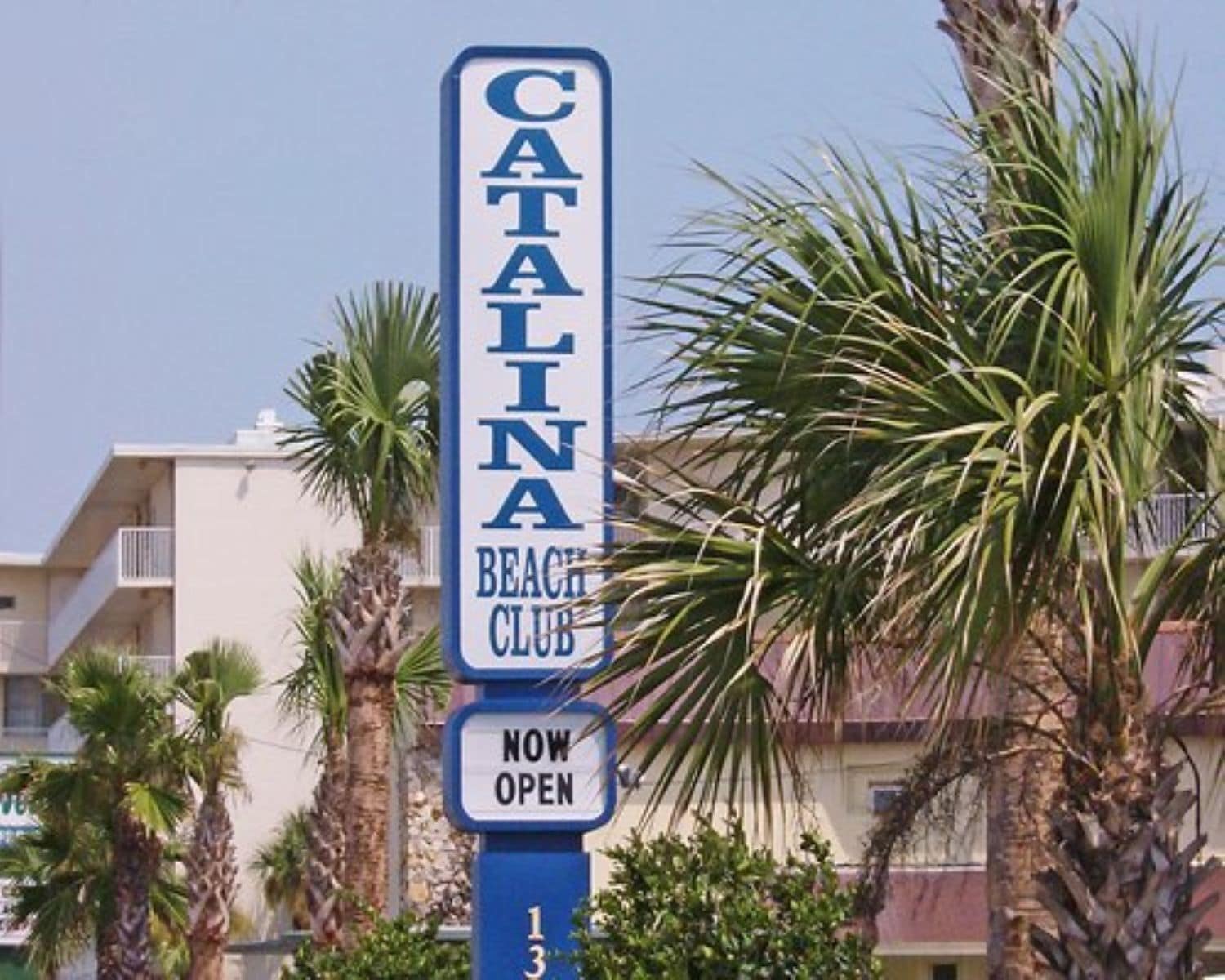 Un letrero para Catalina Beach Club con un aviso de 'ABIERTO'.