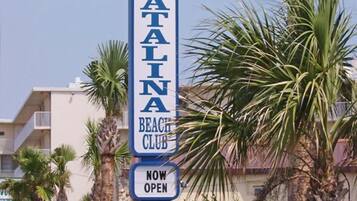 A sign for Catalina Beach Club with a 'NOW OPEN' notice.