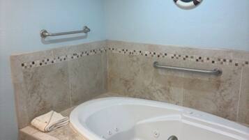 Ein Badezimmer mit Badewanne, Haltegriffen und einem 'Welcome'-Schild.