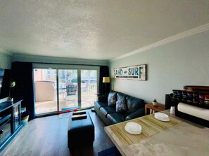 Una sala de estar con un sofá, una mesa de centro y un letrero que dice 'SAND AND SURF'.