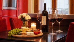 Una cucina moderna con mobili rossi, forno a incasso e zona pranzo con tavolo apparecchiato per un pasto.