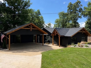 A two-story building with a covered garage and a smaller attached structure. - Lakefront Escape in Hot Springs 2BR/2BA, Hot Tub, Fireplace & Boat Slips (Hot Springs National Park)