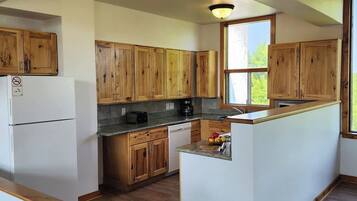 A kitchen with wooden cabinets, a central island, and a large window.