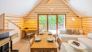 A cozy cabin with a dining area, a sofa, and a wooden ceiling. - “L’aubier des Bauges” Apartment: Mountain View, Private Terrace, Wi-Fi (Les Déserts)