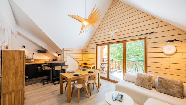 A modern interior with a dining area, kitchen, and a cozy seating area with a view to the outdoors. - “L’aubier des Bauges” Apartment: Mountain View, Private Terrace, Wi-Fi (Les Déserts)
