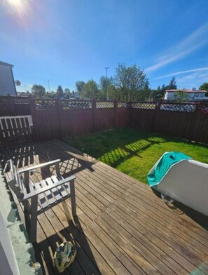 A wooden deck with a grill and a covered barbecue area. - Serene 3-bedroom apartment in Reykjavík perfect for your getaway (Reykjavík)