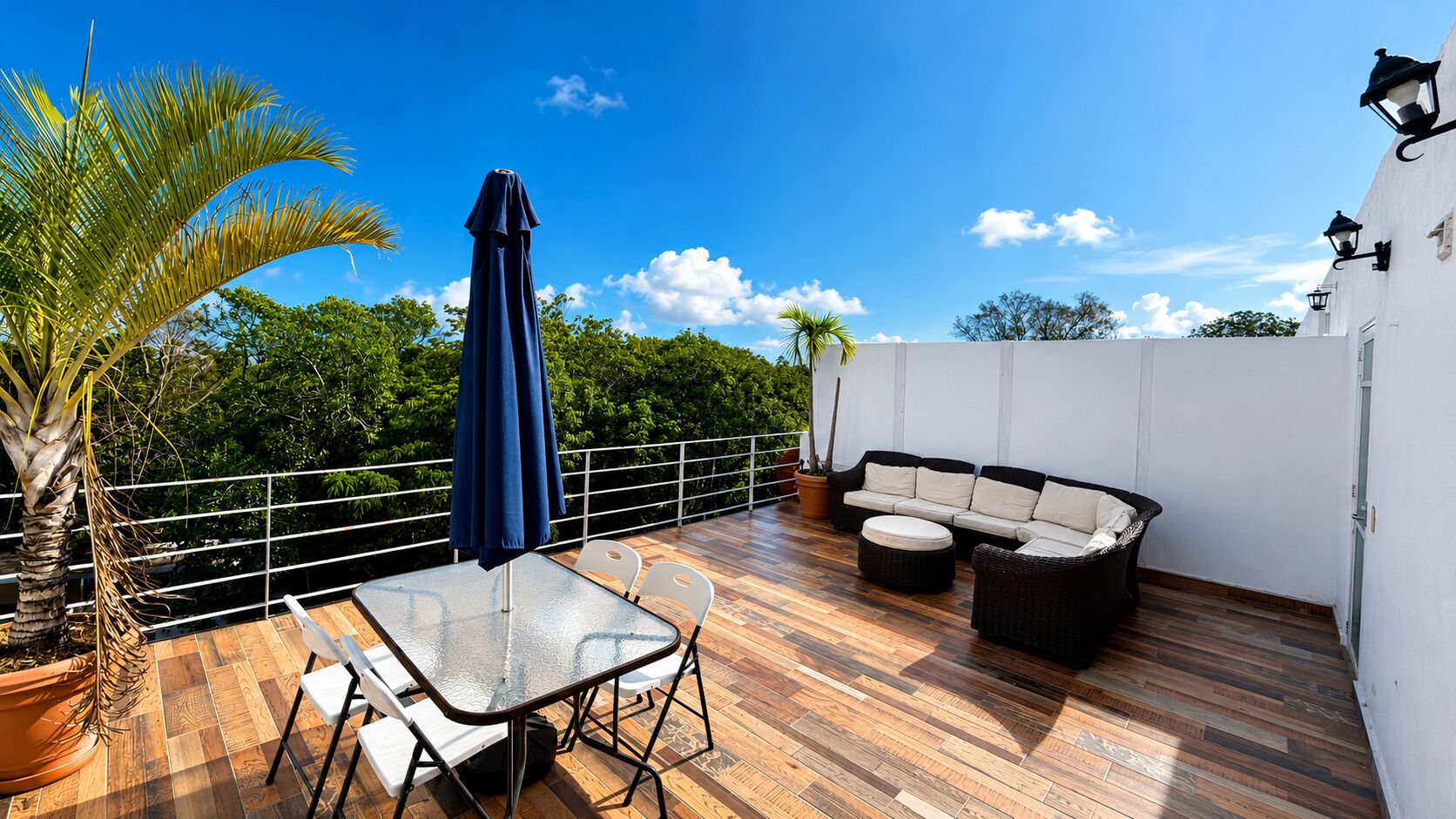 Una terrazza sul tetto con tavolo, sedie, divano e ombrellone.