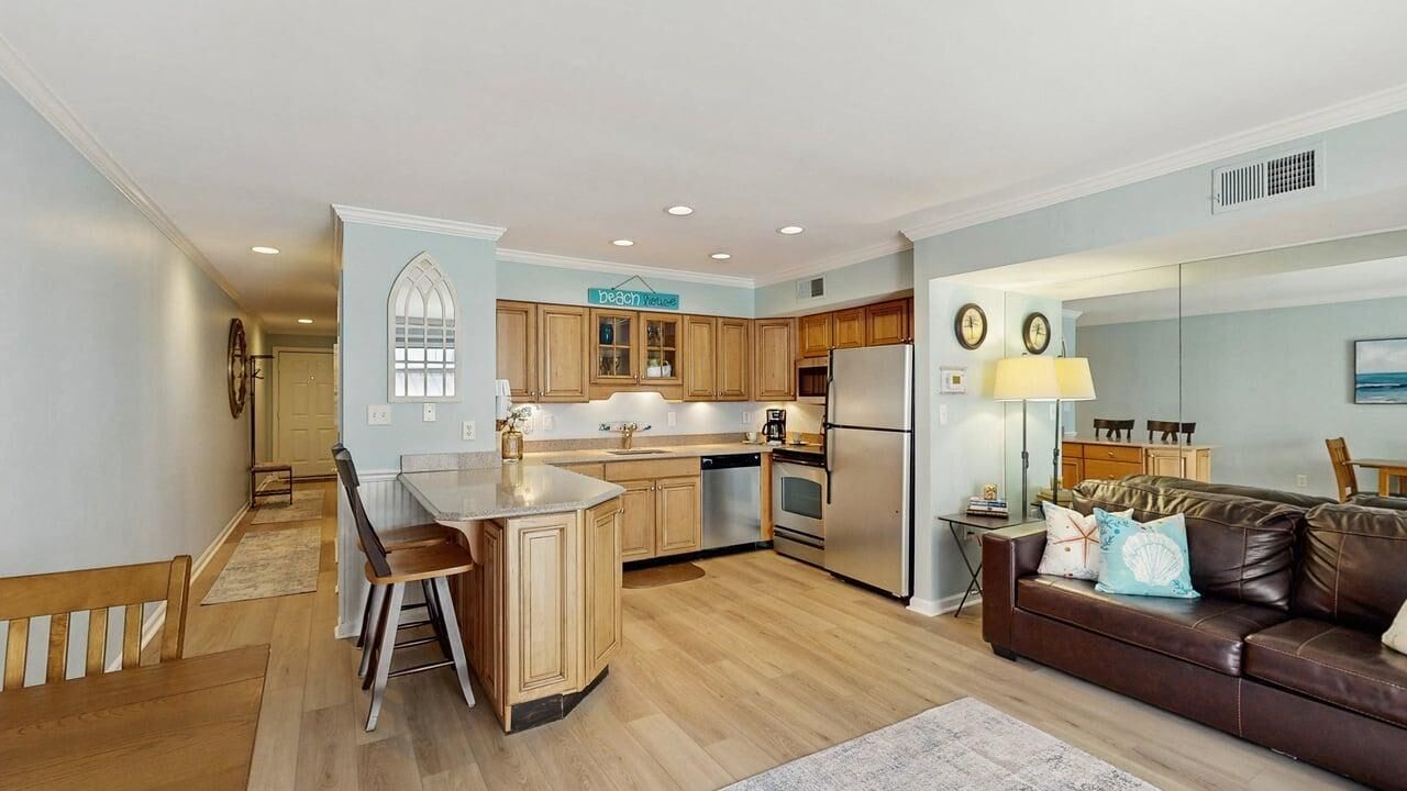A modern kitchen with wooden cabinets, a central island, and a dining area with a bench.
