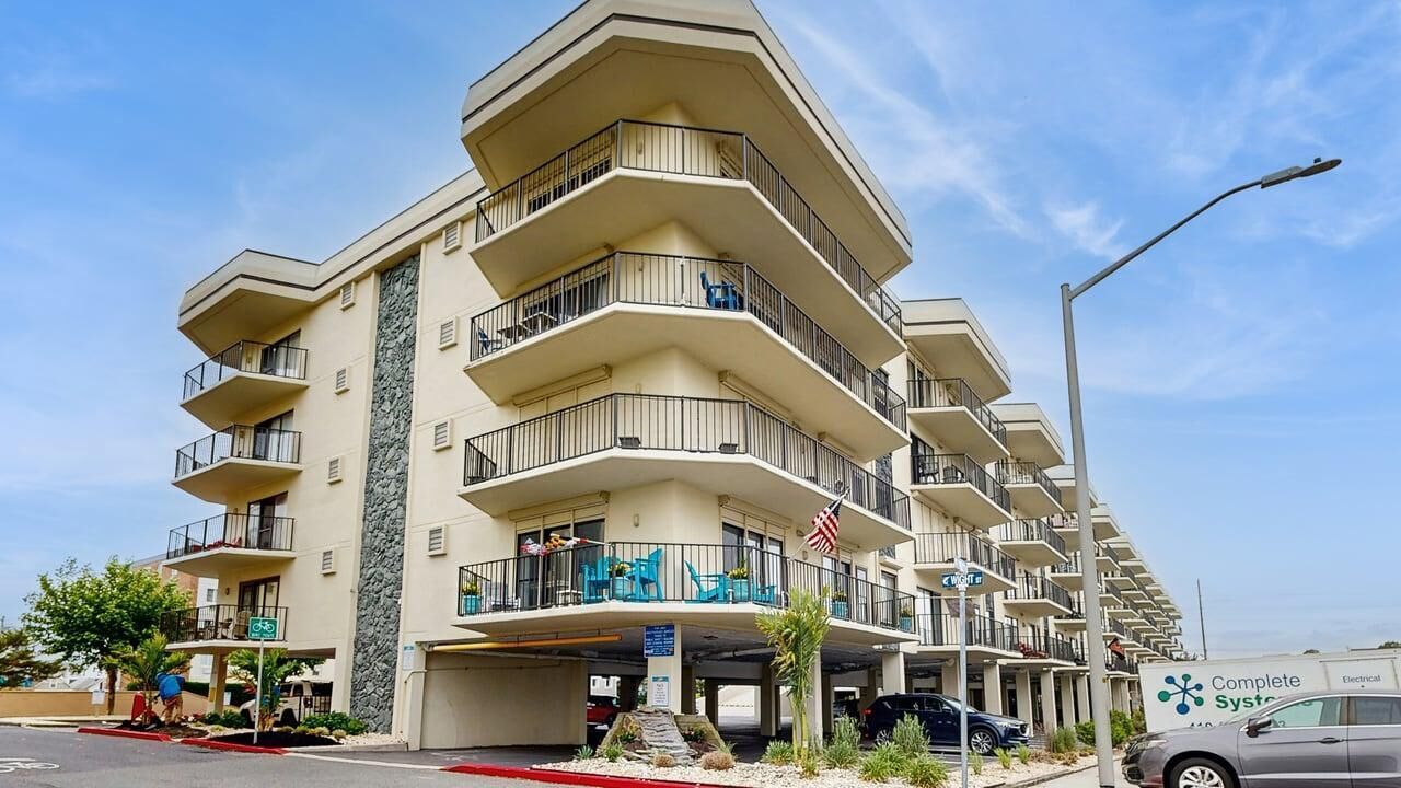 A multi-story hotel with balconies, a parking garage, and an American flag.