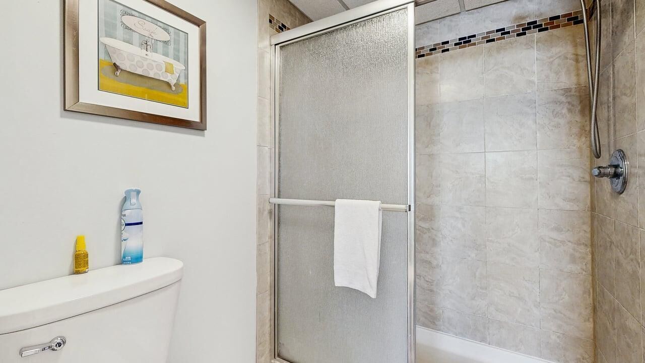 A bathroom with a shower, a toilet, and a sink.