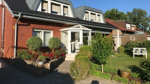 A modern two-story house with a brick facade, a covered porch, and a well-maintained garden. - Leling Holiday Apartment – Relaxation with a Wellness View (Havixbeck)