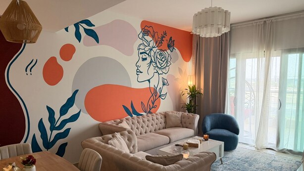 A modern living room with a sofa, armchair, and a coffee table. - Modern Comforts: Al Raha Beach modern 1 bedroom near AD airport (Abu Dhabi)