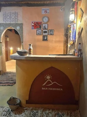 Un comptoir d’accueil agrémenté d’une horloge, de tableaux encadrés et du logo de « Dar Menorca ».
