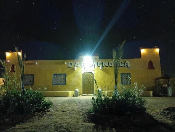 Un edificio con un letrero que dice 'DALIMENOA' de noche.