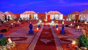 A series of tents with a central walkway, surrounded by seating areas and tables.