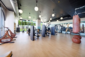 Ein Fitnessstudio mit Trainingsgeräten, Sandsäcken und großen Fenstern.