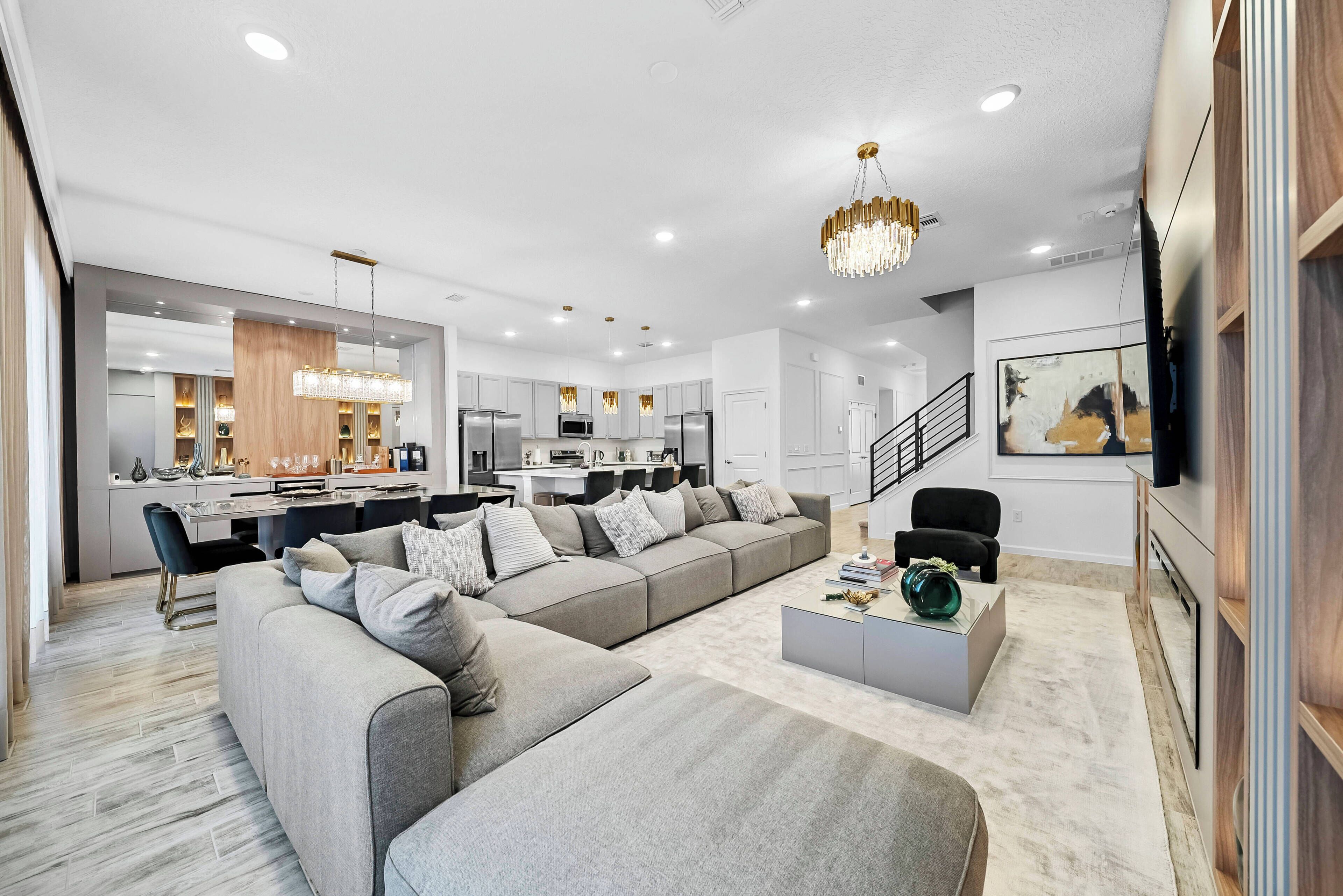 A modern living room with a sectional sofa, a coffee table, and a kitchen in the background.