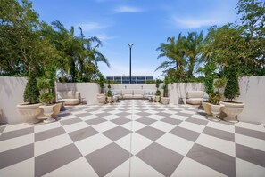A checkered outdoor patio area with seating and planters. - At Nomad Residences wynwood: 2BR apartment (Miami)