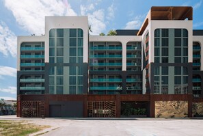 Ein modernes Mehrstöckiges Hotel mit großen Fenstern, Balkonen und einem Innenhof.