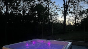 A hot tub with purple lights, surrounded by trees. - Secluded 5BR Retreat w/ Hot Tub, Sleeps 10 (Canfield)