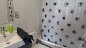 Une salle de bain avec des toilettes, un lavabo et un rideau de douche.