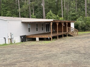 A single-story building with a covered porch and a staircase leading to a door. -  Cozy Lake Getaway Near Toledo Town (Many)