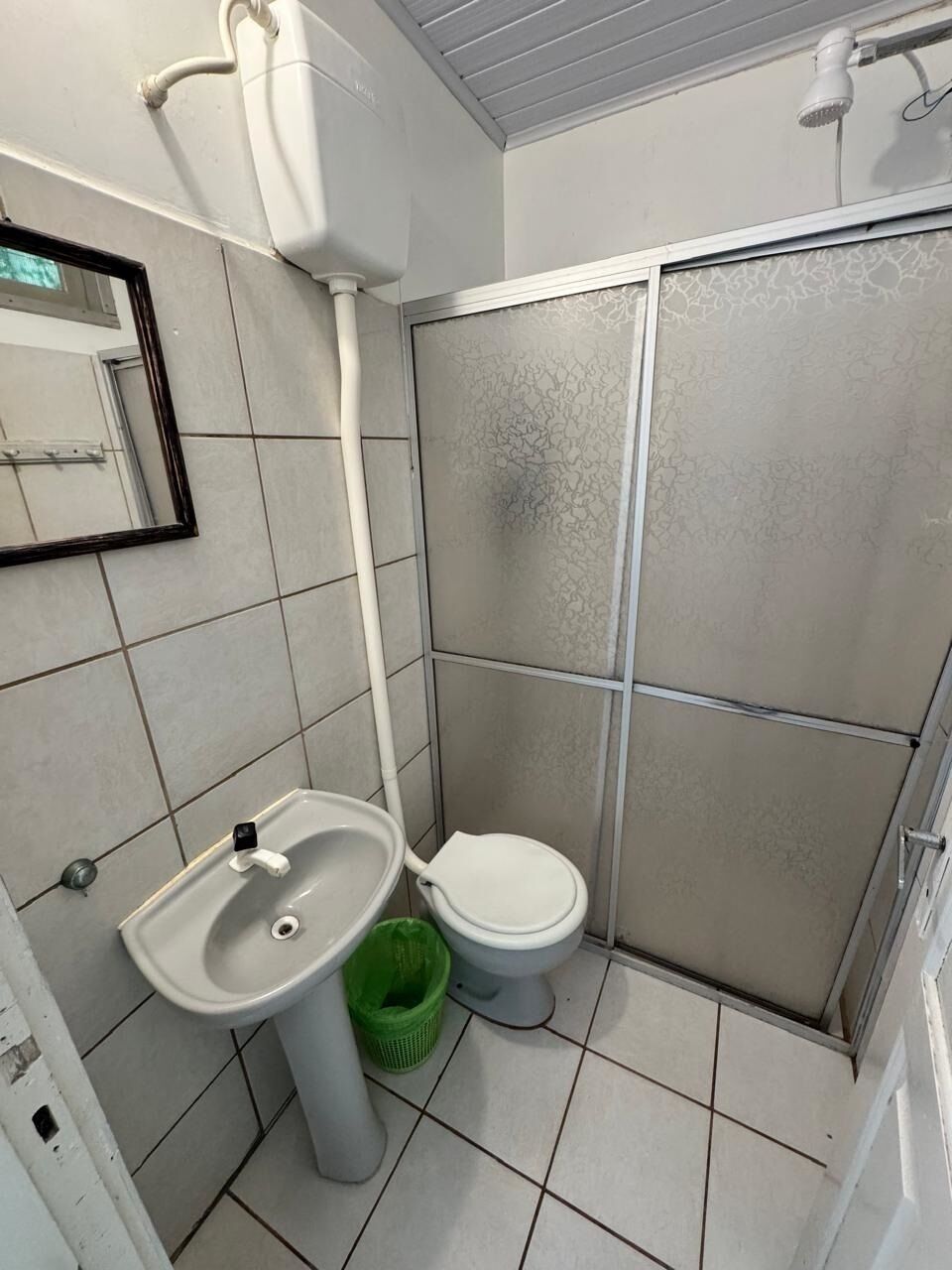 A bathroom with a sink, toilet, and shower enclosure.