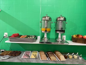 A breakfast buffet with various food items and two beverage dispensers. - Pousada Charlie Brown (Garopaba)