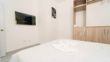 Une chambre à coucher avec un lit, une armoire, un miroir et un tableau accroché au mur.