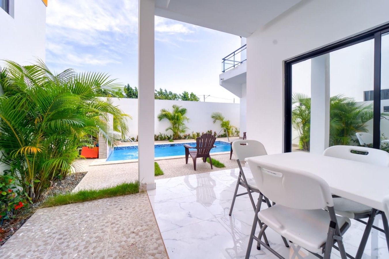 Una moderna terrazza esterna con piscina, area relax e vista sul cielo.