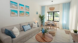 A living room with a sofa, coffee table, and artwork on the wall. - Oasis Retreat | Sleeps 4 | Free Airport Transfer (Punta Cana)
