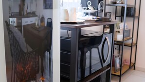 A modern kitchen with a black countertop, a coffee machine, and a shelf with kitchenware. - Holiday Apartment for 2 People (40 m²) in Kerpen (Eifel) (Kerpen (Eifel))