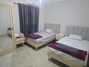 A room with two beds, a wardrobe, a nightstand, and a mirror. - Lavesta 6 Sea View Chalet
Luxury with 3 bedrooms, 2 bathrooms & relaxing vibes. (Suez Governorate)
