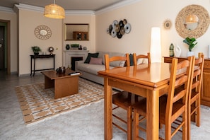 Ein Wohnzimmer mit Holzesstisch, Stühlen, einer Couch, einem Couchtisch und einem Kamin.