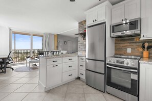 A modern kitchen with white cabinets, a stainless steel refrigerator, an oven, and a microwave. - Spectacular Gulf Views Close To Beach Studio 4606 (Bonita Springs)