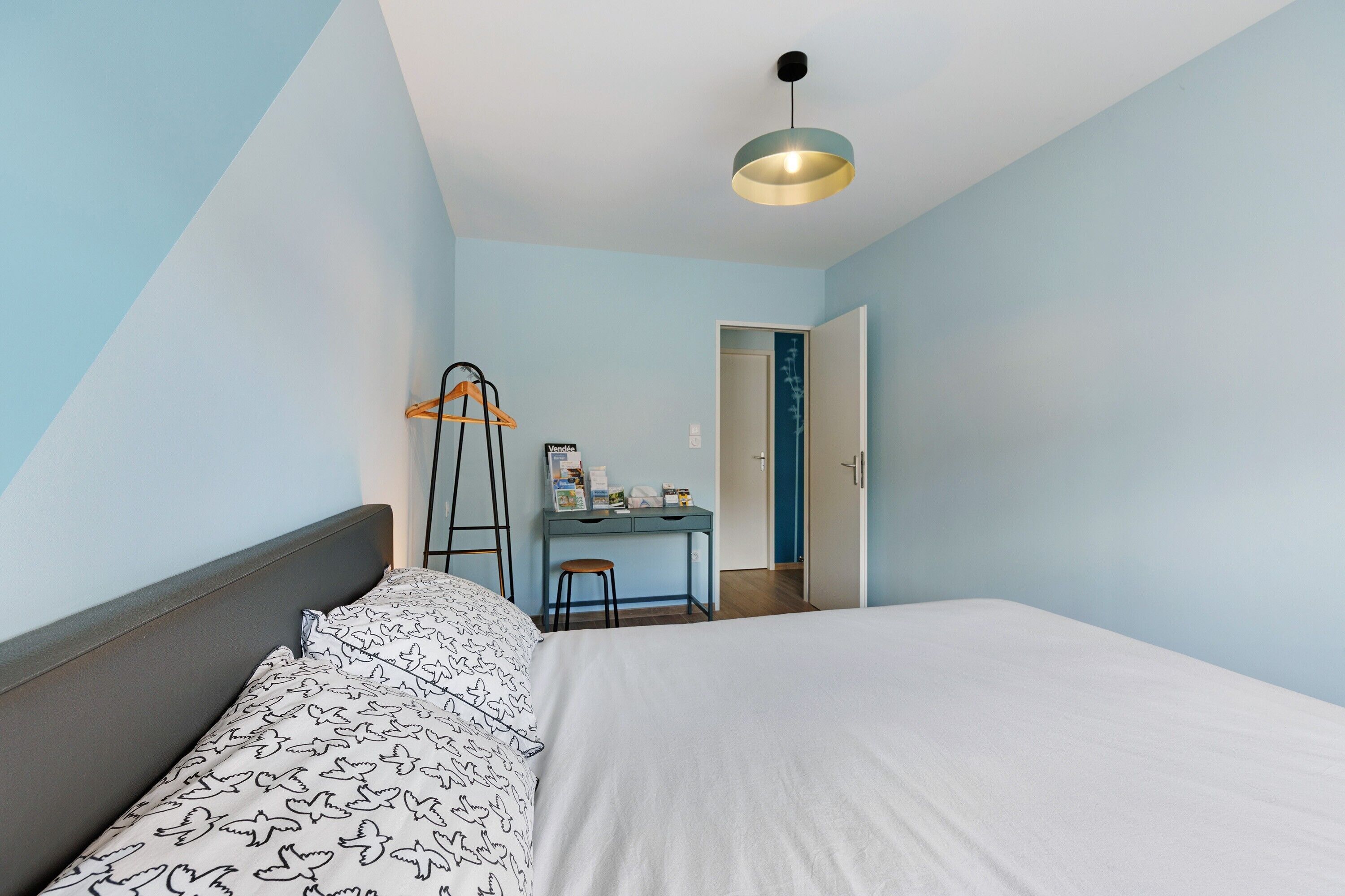 Ein Schlafzimmer mit Bett, Schreibtisch und Stuhl.