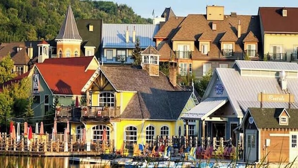 A waterfront hotel with multiple buildings, a dock, and a small boat.
