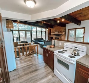 A kitchen with a large stove, wooden cabinets, and a view of the outdoors.