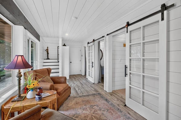 A hallway with a brown leather sofa, a lamp, and a patterned rug. - Wine Country Horse Farm Cabin Near Wineries! (Sherwood)