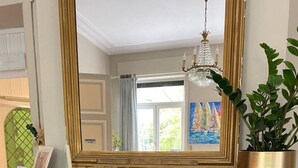 A fireplace with a fire, a mirror above it, and a plant on the mantel. - Hotel Entree - Private Balcony View of Canal (Brugge)