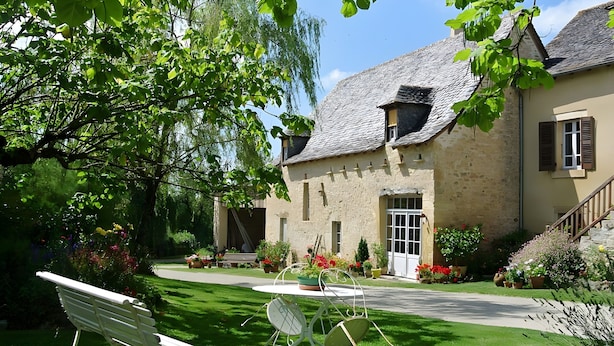 A stone building with a garden, a bench, and a table with chairs. - Guest Room 'La Grange De La Bonaurie - Havane' with Shared Terrace and Garden (Anglars-Saint-Félix)