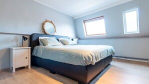 A bedroom with a bed, bedside tables, a mirror, and two windows. - Spacious Bruges House with Free Parking (Brugge)