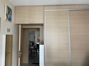 A room with a sliding door, a small kitchenette, and a dining area. - Elegant Apartment in a Secured Residence with Pool Near the Beach (Bouznika)