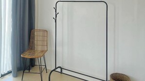 A room with a standing screen, a chair, a woven basket, and an air conditioning unit.