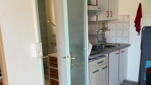 Een keuken met witte kastjes, een spoelbak en een houten vloer.