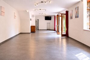 Un vaste couloir doté d’un plancher plat, d’une horloge et d’un téléviseur fixé au mur.