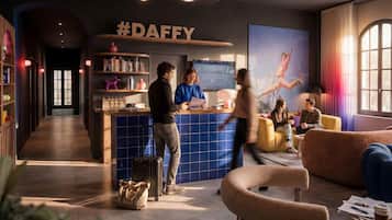 En modern hotellobby med en receptionsdisk, en sittgrupp och ett stort fönster.