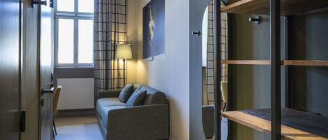 A modern interior with a sofa, a lamp, and a bookshelf.
