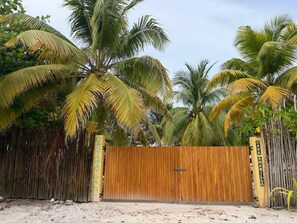 Ein hölzernes Tor mit der Aufschrift 'CASTAWAY PALMS', umgeben von Palmen.